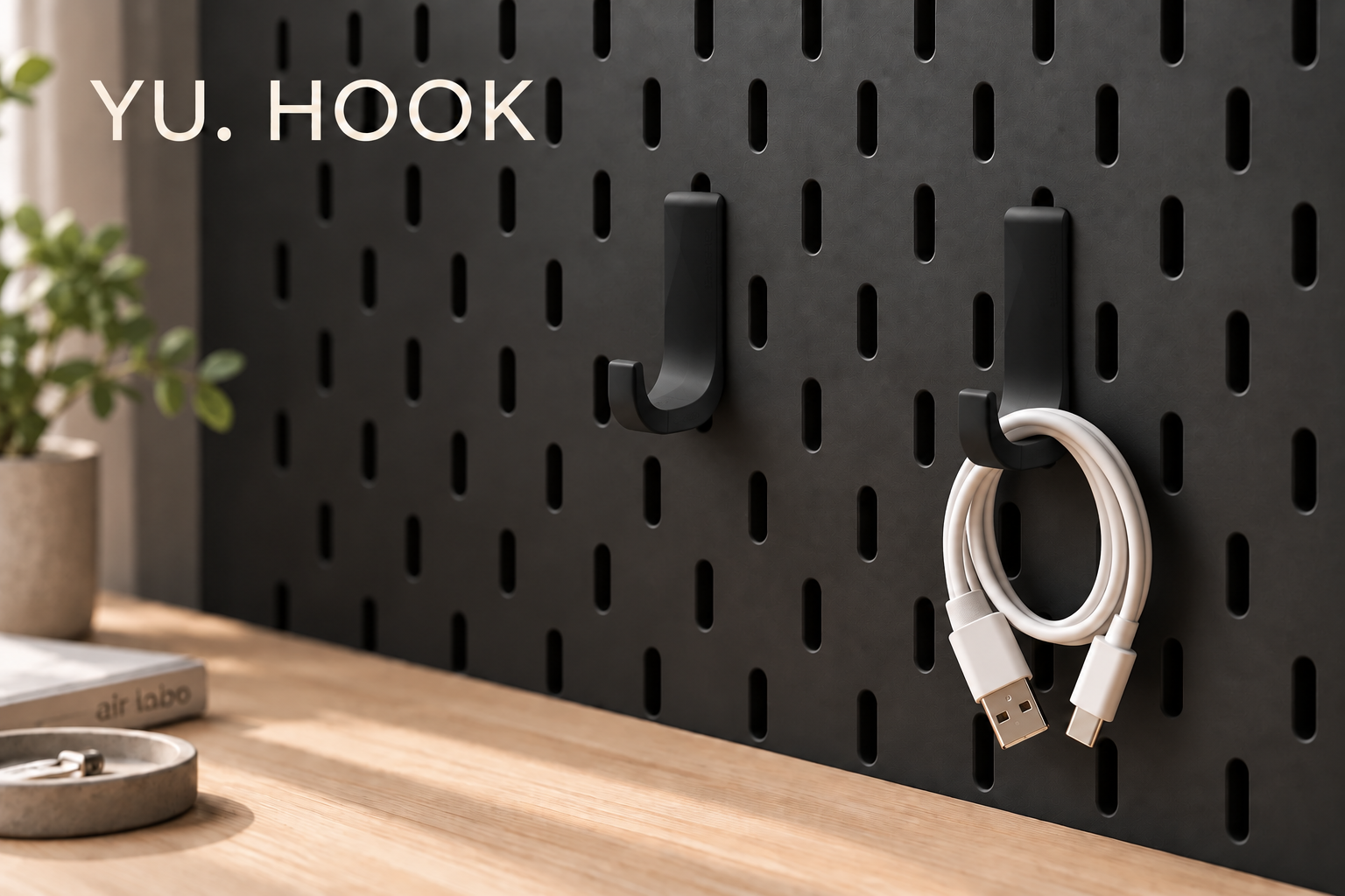 先端が1本のYU. HOOKにUSBケーブルを掛けた、黒いボードでの使用イメージ